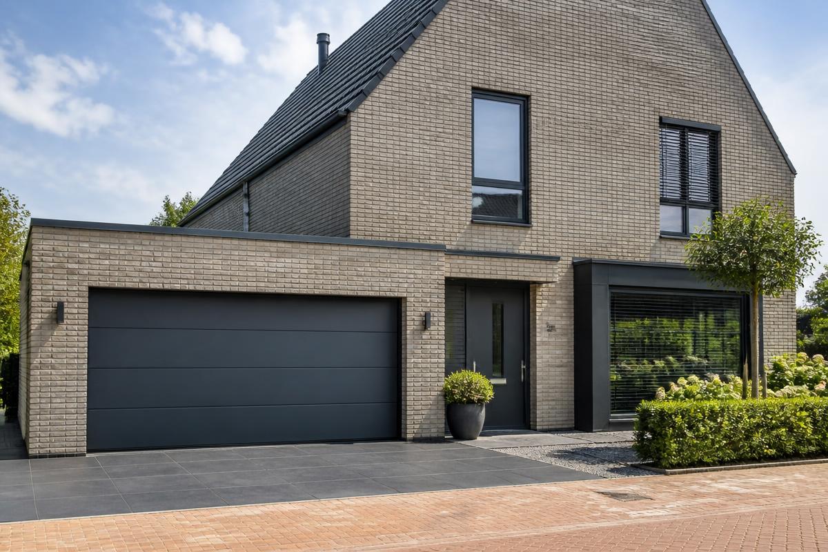 Nieuwe sectionale garagedeur wordt geplaatst bij een woning
